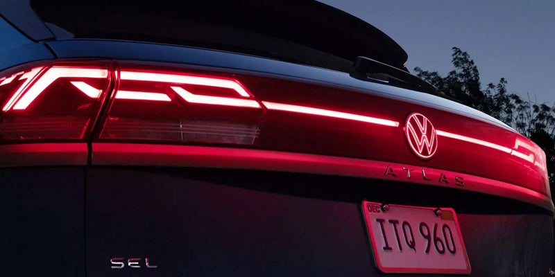 Rear view of 2026 Volkswagen Atlas Cross Sport with illuminated LED taillights.
