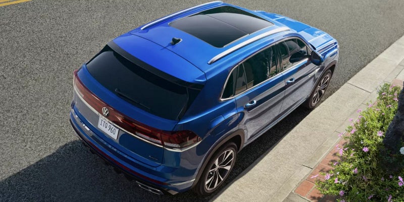 Overhead view of a blue 2026 Volkswagen Atlas Cross Sport parked along a curb.)