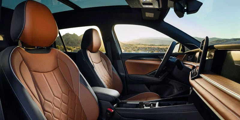 Volkswagen Tiguan front seats with brown leather interior and panoramic sunroof.