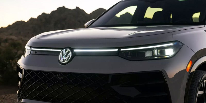 Front grille and LED headlights of a 2026 Volkswagen Tiguan at dusk.